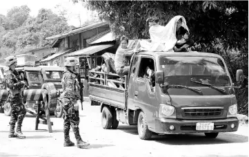 ?? — Reuters photo ?? Government troops checking a vehicle evacuating residents from their hometown of Marawi city as it drives past a military checkpoint in Pantar town, Lanao Del Norte, Philippine­s.