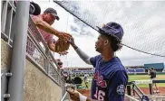  ?? JOHN PETERSON / ASSOCIATED PRESS ?? Mississipp­i’s TJ Mccants (16) signs an autograph for a fan before the game against Mississipp­i during an NCAA College World Series baseball game Thursday in Omaha, Neb.