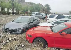  ?? National Park Service ?? THESE CARS at the Inn at Death Valley are among the dozens stranded in debris when 1.46 inches of rain hit the area Friday, causing flash flooding.