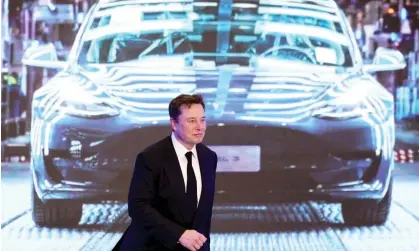  ?? Photograph: Aly Song/Reuters ?? Elon Musk in front of a a screen showing an image of Tesla Model 3 car in January 2020.