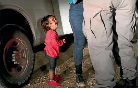  ?? GETTY IMAGES ?? A 2-year-old Honduran asylum seeker cries as her mother is searched and detained near the US-Mexico border. The asylum seekers were detained before being sent to a processing center for possible separation.