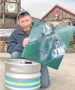  ?? Picture: Angus Findlay. ?? Cairn o’ Mohr owner Ron Gillies with a barrel of the new cider and an aerial photograph which shows the outline of the ancient Pictish settlement.