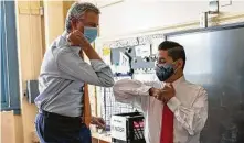  ?? Jeenah Moon / Bloomberg ?? New York City Mayor Bill de Blasio, left, elbow bumps Richard Carranza, chancellor of the New York City Department of Education, right, during a news conference Wednesday.