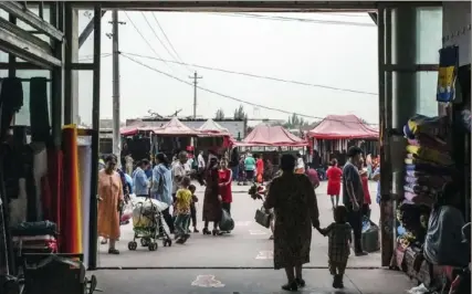  ?? Gilles Sabrié/The New York Times ?? People visit the Hotan bazaar in Xinjiang, China. The Taliban gave haven to Uyghur fighters resisting Chinese rule in Xinjiang when they were in power in Afghanista­n.