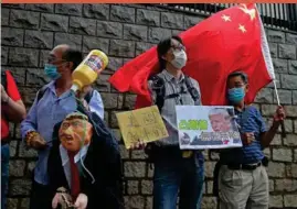  ??  ?? Pro-china supporters hit the effigy of U.S. President Donald Trump outside the U.S. Consulate in Hong Kong