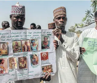  ?? /AFP ?? Grim memories: Parents and relatives of girls abducted by Boko Haram rebels hold their pictures at municipal offices in Chibok on Sunday. On April 14 2014, gunmen stormed a boarding school, kidnapping 276 pupils, of whom. 112 are still missing.