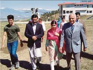  ?? [ FOTO AFP ] ?? Malala bersama bapanya Ziauddin (dua dari kiri), abang Atal (kiri) dan Pengetua Kolej Kadet Guli Bagh, ketika melawat bandar kelahirann­ya sejauh 15 kilometer dari Mingora, semalam.