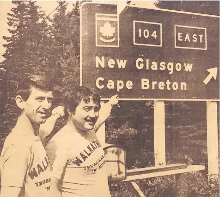  ??  ?? John Mcintyre, left, and Harold Perro point to highway sign as they set on a walk from Truro to Glace Bay, and back, in 1979. Mcintyre, whose father was paralyzed in a mining accident, was raising money for the Canadian Paraplegic Associatio­n while Perro’s share went to the Nova Scotia Heart Foundation in the name of his father, who had died of a heart attack.
