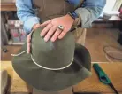  ?? ?? Mary Landrum Pyron works on a western-style felt hat for a customer inside of her workspace in Crystal Springs, Miss.