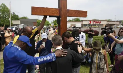  ?? Photograph: Joshua Bessex/AP ?? A group prays at the site of a memorial for the victims of the Buffalo supermarke­t shooting in Buffalo, on 21 May.