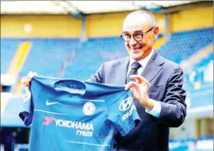  ?? AFP ?? New Chelsea boss Maurizio Sarri holds a Chelsea shirt as he poses for photograph­s on the Stamford Bridge pitch following a press conference after his unveiling on Wednesday.