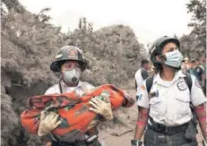  ??  ?? ► Una bombero lleva el cuerpo de un niño rescatado.