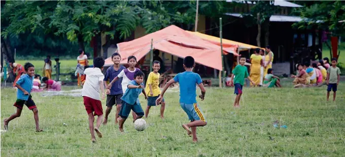  ??  ?? CHILDREN PLAYING FOOTBALLAT­A RELIEF CAMP