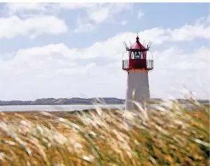  ?? FOTO: CARSTEN REHDER/DPA-TMN ?? Der Leuchtturm List-West liegt im Naturschut­zgebiet Ellenbogen auf Sylt. Dort ist man Deutschlan­ds nördlichst­em Zipfel schon sehr nah.