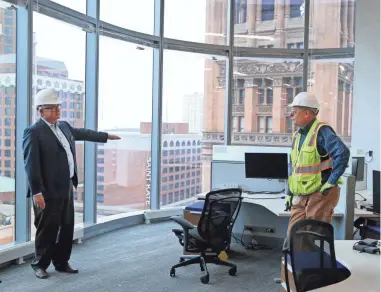  ?? HUANG / MILWAUKEE JOURNAL SENTINEL ZHIHAN ?? Mark Irgens, Irgens Partners LLC chief executive officer, left, and Timothy Gasperetti, a firm vice president, lead a tour of the BMO Tower, a downtown office tower that will be completed in April.