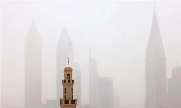 ?? (AFP) ?? A view of the haze obscuring the skyline of the Gulf emirate of Dubai with a mosque in the foreground during a heavy sandstorm on Wednesday