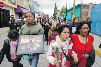 ?? MOISES CASTILLO, THE ASSOCIATED PRESS ?? Relatives accompany the remains of firefighte­rs who died in the explosion of several fireworks workshops, after a memorial, in Tultepec, Mexico, on Friday.