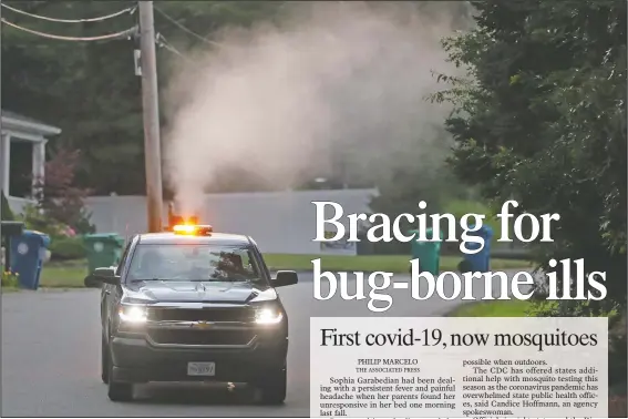  ?? (AP/Charles Krupa) ?? A crew from the East Middlesex Mosquito Control Project spray to control mosquitos from a pickup Wednesday while driving through a neighborho­od in Burlington, Mass.