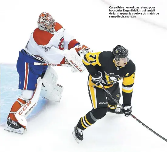  ?? PHOTO AFP ?? Carey Price ne s’est pas retenu pour bousculer Evgeni Malkin qui tentait de lui masquer la vue lors du match de samedi soir.