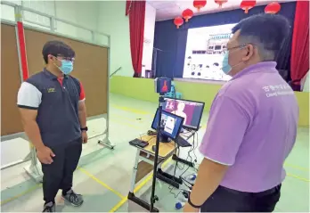  ??  ?? Chung Hua Middle School No.1 staff seen testing the thermal imaging camera at the school yesterday. - Photo by Roystein Emmor