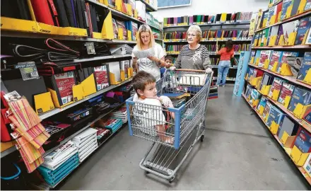  ?? Karen Warren / Staff photograph­er ?? Faye Russell pushes her great-grandson Marcus Masters, 8, as she helps granddaugh­ter Korey Masters shop for school supplies at Walmart on Silber Road. The El Paso shooting prompted increased presence of security guards such as Charles Levier, top.