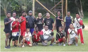  ?? RIANA SETIAWAN/JAWA POS ?? SEMANGAT: Pelatih wushu Papua Nicky Ilolu (berdiri empat dari kanan) bersama anak buahnya setelah berlatih di Lapangan SPN, Jayapura. Mereka menargetka­n dua emas.