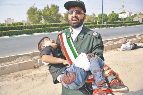  ??  ?? Un soldado iraní auxilia a un niño herido durante el ataque de ayer en la ciudad de Ahvaz, en el suroeste del país.