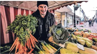  ?? RP-FOTO: VAN OFFERN ?? Micho Kolak in seinem Marktstand an der Kavariners­traße. Für die kalte Jahreszeit empfiehlt er unter anderem Möhren und Wirsing. Auch Grünkohl und Endiviensa­lat schmecken im Dezember besonders gut.