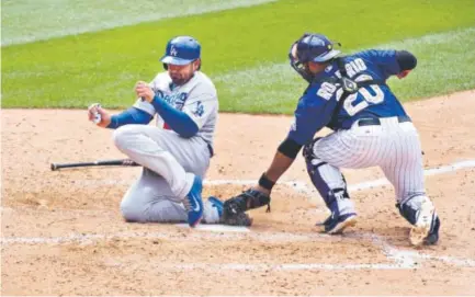  ??  ?? Adrian Gonzalez scores for the Dodgers, beating Rockies catcherWil­in Rosario to the plate Sunday at Coors Field. The NLWestlead­ing Dodgers won 8-2 for their third victory in the four-game series. Colorado fell to 37-52. story, 5B John Leyba, The Denver...