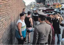  ?? CHIANG MAI NEWS THE ASSOCIATED PRESS ?? Canadian Brittney Schneider, left, and Briton Furlong Lee, second left, in front of Tha Pae Gate in Chiang Mai province, Thailand. They face up to 10 years in prison on charges of spraying paint on an ancient wall.