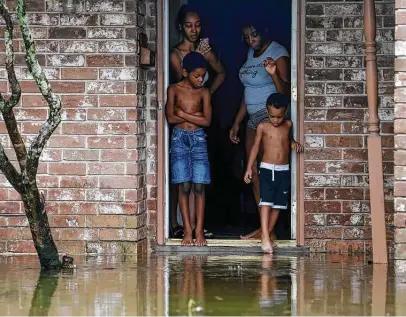  ?? Godofredo A. Vásquez / Staff photograph­er ?? Cam’ron Maltie, 8, left, and Adrian Murray, 4, look at their flooded front lawn Tuesday during Tropical Storm Beta. Their family has been living in the Houston home for a year and didn’t know the neighborho­od flooded.