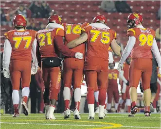  ?? ELIZABETH CAMERON ?? Quarterbac­k Jimmy Underdahl is helped off the field by teammates after injuring his knee against the Manitoba Bisons. With Underdahl out of the lineup, the Dinos will turn to a pair of rookie backups.