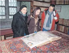  ?? FOTO: HARALD STRITTMATT­ER ?? Dorothea von Fintel, Munkhshur Damdinbaat­ar und Stadtpfarr­er Dietrich Oehring (von links) in der Prädikante­nbibliothe­k.