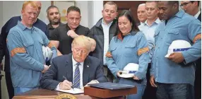  ?? MANDEL NGAN/AFP/GETTY IMAGES ?? President Donald Trump signs Section 232 Proclamati­ons on Steel and Aluminum Imports in the Oval Office of the White House last Thursday.