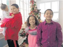  ?? COURTESY ?? At Christmas 2017, Michael Jordan-Benfer, left, holds his baby sister, Nevaeh. On the right is sister Chanda, now 9, and brother Robert Jr., now 8.