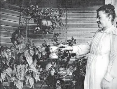  ?? Courtesy photo ?? This candid, everyday shot was probably less about the woman and more about the plants. Images of America Van Buren includes a collection of anonymous photos bought in a local antiques store by Ray Wallace, former provost of the University of...