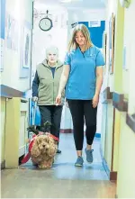  ??  ?? Care assistant Caris Rose walking with Nancy and Penny through the care home.