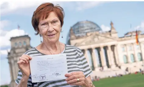  ?? FOTO: DPA ?? „Reichstags­baby“Mareile Van der Wyst steht mit ihrer Geburtsurk­unde vor dem Bundestags­gebäude in Berlin.