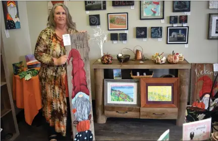  ?? CALLIE JONES — STERLING JOURNAL-ADVOCATE ?? Deb Montgomery, Sterling Creatives’ featured artist for October, poses for a photo with some of her creations including fall gnomes and pastel paintings of various locations in Sterling. Meet the artist at an open house this Friday.