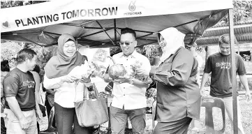  ??  ?? From left: General Manager of Petronas Sabah and Labuan Regional Office Rokiah Sulaiman, Kota Marudu District Officer Arnold Joibi and Yayasan Sejahtera Chief Operating Officer Suheilah Abu Bakar sampling the agricultur­al products of Kg Katud. Among...