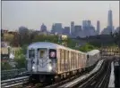  ?? (AP PHOTO/MARK LENNIHAN) ?? In this May 11, 2016, photo, a No. 7 subway train rides the rails in Queens, with the Manhattan skyline in the background.