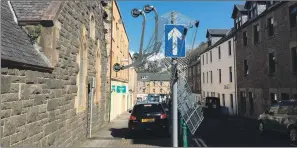  ??  ?? Tesco says it has organised a specialist recovery team to take away the supermarke­t trolleys dumped at and in the Black Lynn burn – and one that somehow found its way onto the top of a street sign in Oban.