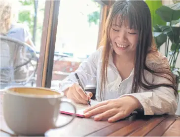  ??  ?? ABOVE
Chinese artist River Rui sketches images of her ‘Silly Piggy’ character at a cafe in Shanghai.