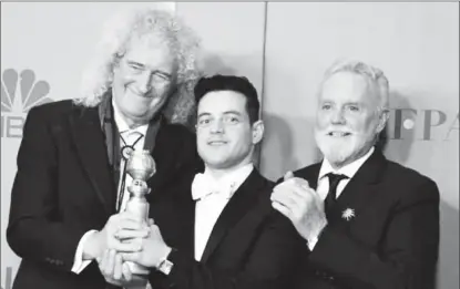  ?? (wionews.com photo) ?? Queen band members Roger Taylor (R) and Brian May (L) pose with Rami Male.