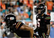  ?? MARK BROWN / GETTY IMAGES ?? Miami freshman N’Kosi Perry (5) finished 8 of 12 for 125 yards with one touchdown and one intercepti­on in his starting debut Thursday against North Carolina, a 47-10 victory.