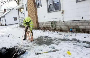  ?? Laura McDermott/The New York Times ?? A worker uses copper pipe to replace an old lead water pipe in January 2016 for a home in Lansing, Mich. Environmen­tal advocates are pressing President Joe Biden’s administra­tion to require utilities to speed up projects replacing lead pipes.