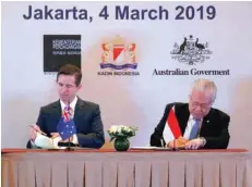  ??  ?? Indonesia’s Trade Minister Enggartias­to Lukita and Australia’s Minister of Trade, Tourism and Investment Simon Birmingham sign an economic partnershi­p pact aimed at boosting trade and investment at a ceremony in Jakarta. — Reuters