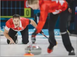  ?? The Associated Press ?? Canada’s John Morris makes a call as teammate Kaitlyn Lawes sweeps the ice during the mixed doubles semifinal match against Norway’s Kristin Skaslien and Magnus Nedregotte­n in Gangneung, South Korea, on Monday. Canada won 8-4.