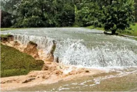  ?? AP PHOTO/BUTCH DILL ?? A hillside is eroded Tuesday as torrential rain falls in Vestavia Hills, Ala.