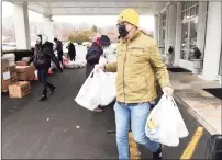  ?? Arnold Gold / Hearst Connecticu­t Media ?? Senior associate paster Mike Bulkley of Kingdom Life Christian Church Cathedral carries bags of food to the parking lot.